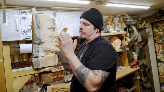 Rene Thomas Reschreiter in seiner Werkstatt beim Schnitzen einer Maske