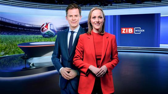 Tobias Pötzelsberger und Alina Zellhofer stehen im modernen Fernsehstudio vor einem Bildschirm mit Sportmotiv und der Aufschrift „ZIB Wissen“.