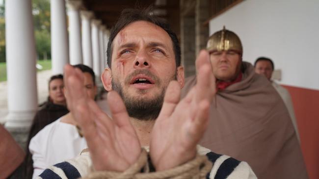 Darsteller des Heiligen Florians streckt die Hände zum Gebet aus