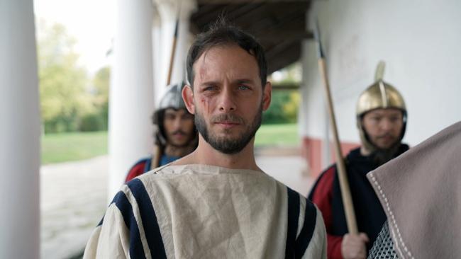 Schauspieler als Heiliger Florian verkleidet, in Begleitung von Wachen.