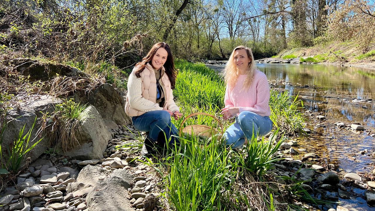 Maggie Entenfellner und Melanie Kogler sitzen am Ufer der Erlauf.