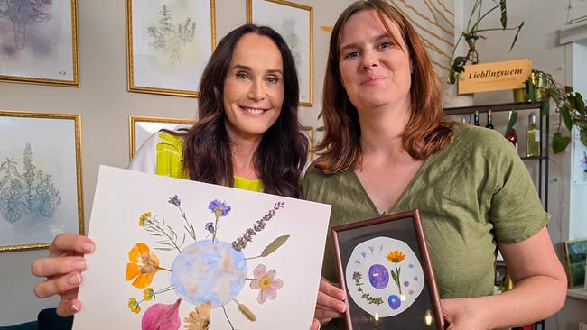 © ORF/Ab Hof TV Produktion Maggie Entenfellner und Marie-Elisabeth Gantner stehen nebeneinander und halten Bilder mit Blumenmotiven vor sich.