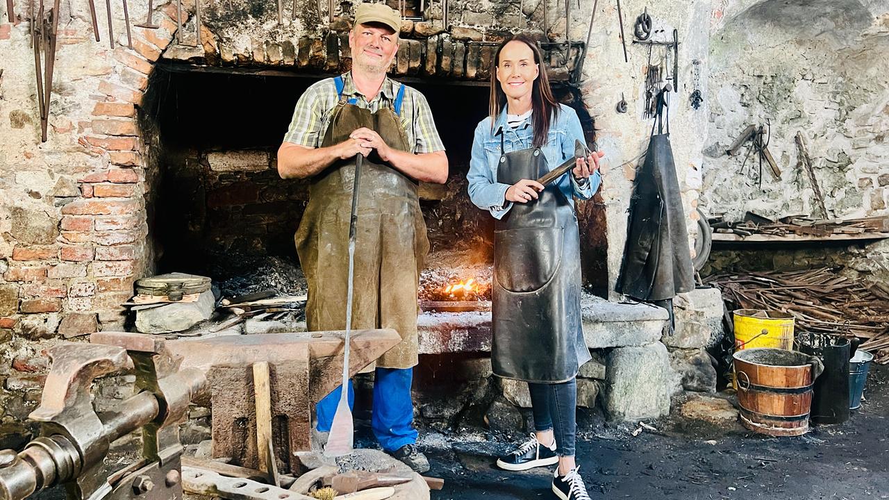 Maggie Entenfellner und Schmied Klaus Kamleitner vor Schmiedefeuer in historischer Hammerschmiede Aggsbach.