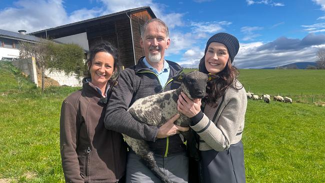 Daniela und Wolfgang Ochabauer und Maggie Entenfellner stehen auf einer Wiese, Wolfgang Ochabauer hält ein Lamm im Arm.