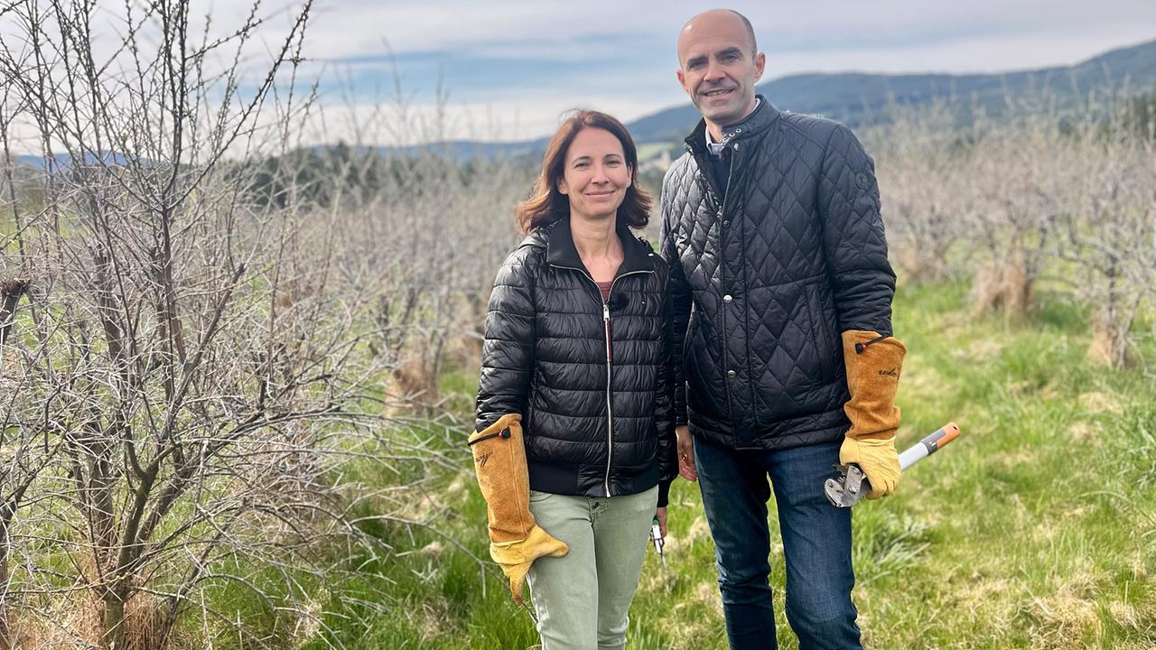 © ORF/Ab Hof TV Produktion Tanja und Gabriel Kroisleitner stehen mit Gartenhandschuhen und Astschere zwischen Sanddornsträuchern.