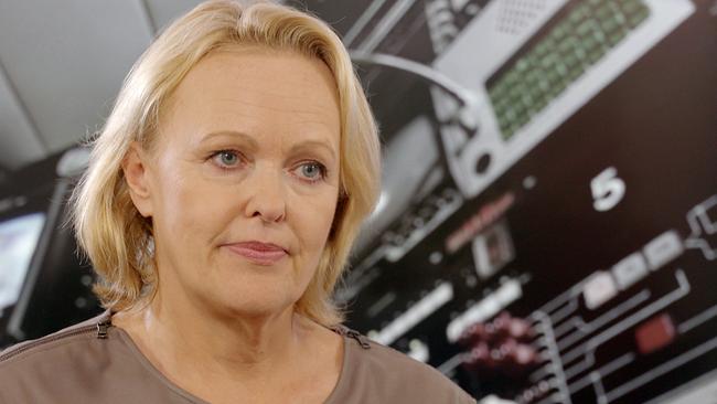 Hannelore Veit ist im Porträt vor einem unscharfen Hintergrund mit technischen Geräten zu sehen.