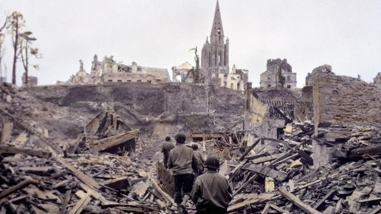 Eine US-Infanteriepatrouille bahnt sich einen Weg durch die Ruinen von Saint Lô. Die französische Stadt wird im Zweiten Weltkrieg zu 95 Prozent zerstört.