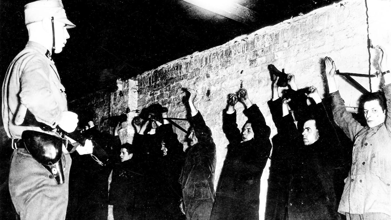 Verfolgung politischer Gegner 1933-1939: Verhaftete Anhänger der "Linken", angekettet an der Wand in einem Keller der SA in der Geschäftsstelle in der Hedemannstrasse in Berlin (Kreuzberg) unter Bewachung eines SA-Mannes, um den 10.03.1933.