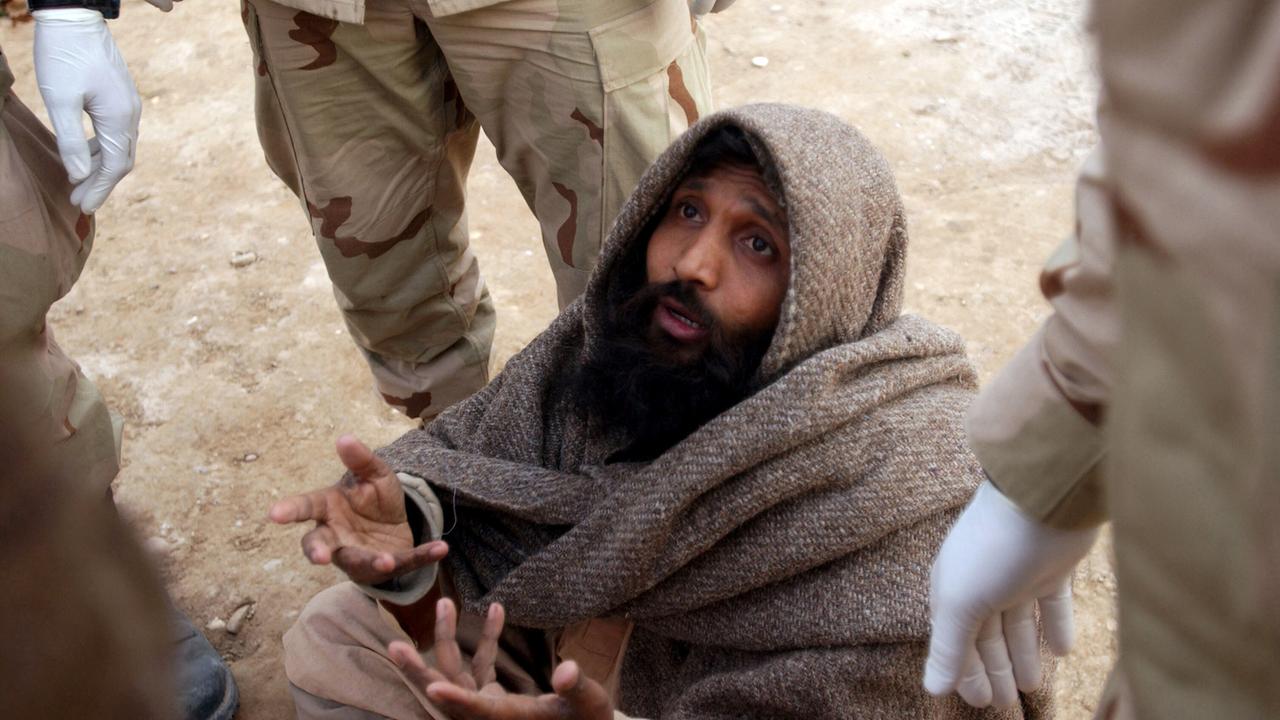 Ein pakistanischer Häftling erklärt Soldaten der US-Armee (USA) der 65. Militärpolizeikompanie, 187. Bataillon, 10. Gebirgsdivision, im Gefängnis von Sherberghan, Afghanistan, während der Operation ENDURING FREEDOM seine Notlage als Taliban-Mitglied.