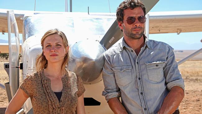 © ORF/ZDF/Boris Guderjahn Johanna Zarrmann und Thomas Marrach stehen vor einem Kleinflugzeug in einer sonnigen, trockenen Landschaft in Afrika.