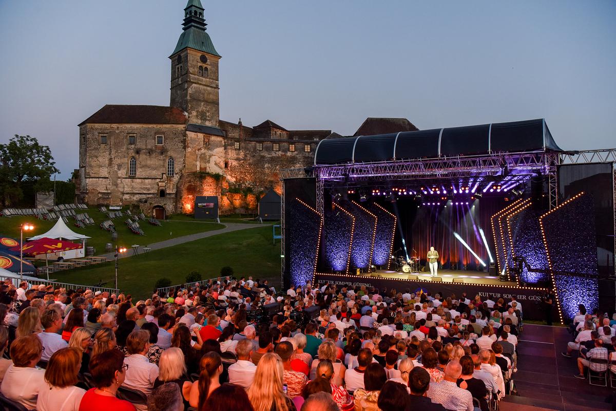 Kabarettstars unter Sternen - Andreas Vitásek & Friends – im Hintergrund Burg Güssing.