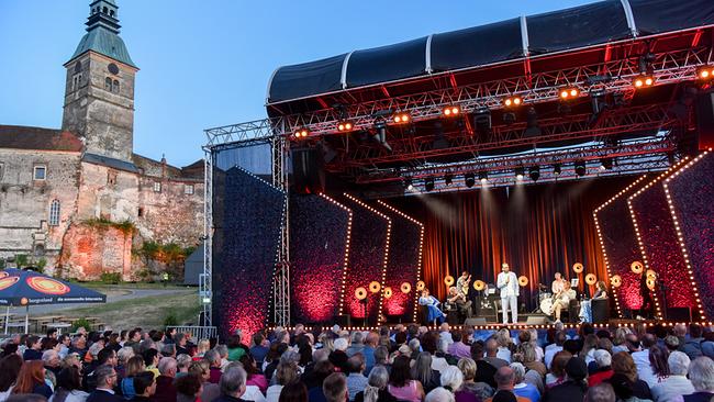 Kabarett unter Sternen: Tafelrunde Open Air: Moderator Gerald Fleischhacker lädt zu einer weiteren Sommer-Ausgabe des Satire Formats "Die Tafelrunde" ein - diesmal vor der wunderschönen Kulisse der Burg Güssing.
