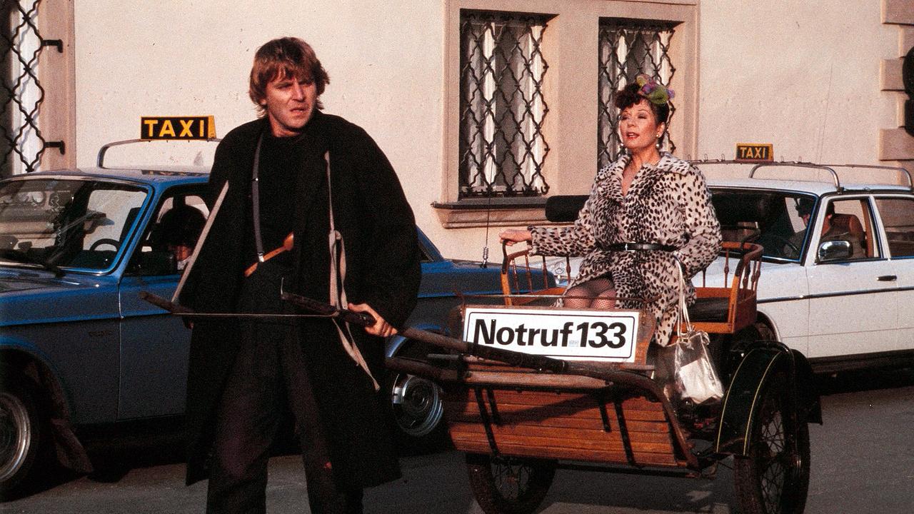Lukas Resetarits zieht Eva Kerbler in einer Kutsche mit der Aufschrift "Notruf 133" durch die Straßen.