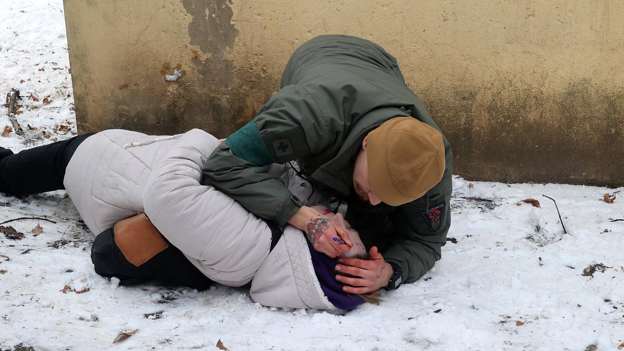 2. Februar 2023 Kramatorsk; ein Sanitäter schreibt einer verwundeten Frau den Namen auf die Stirn