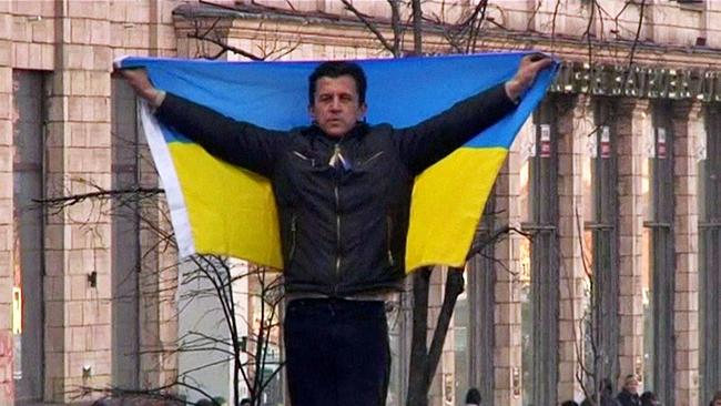 Ein Mann hält die ukrainische Flagge hoch.