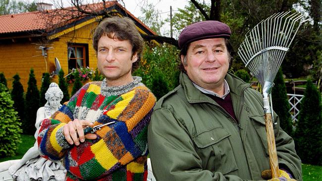© ORF/Hubert Mican Alfred Dorfer mit einer Gartenschere und Erwin Steinhauer mit einem Rechen in der Handstehen vor einem Gartenhaus.