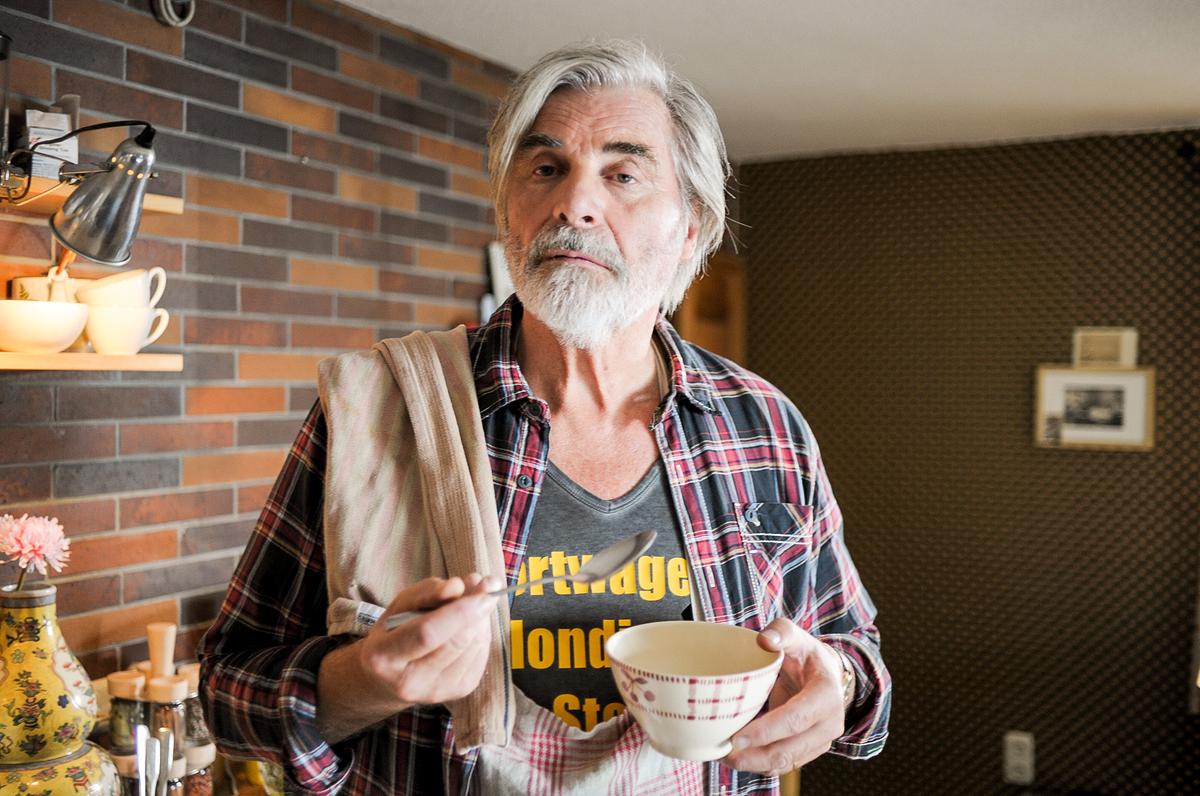 Peter Simnonischek mit einer Schüssel und einem Suppenlöffel in der Hand.