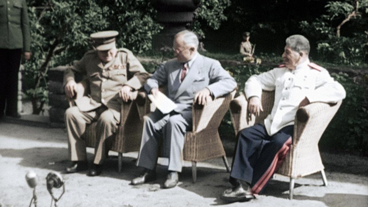 Churchill, Truman und Stalin bei der Potsdamer Konferenz Juli 1945. Alle drei sitzen auf Korbstühlen in Freien.