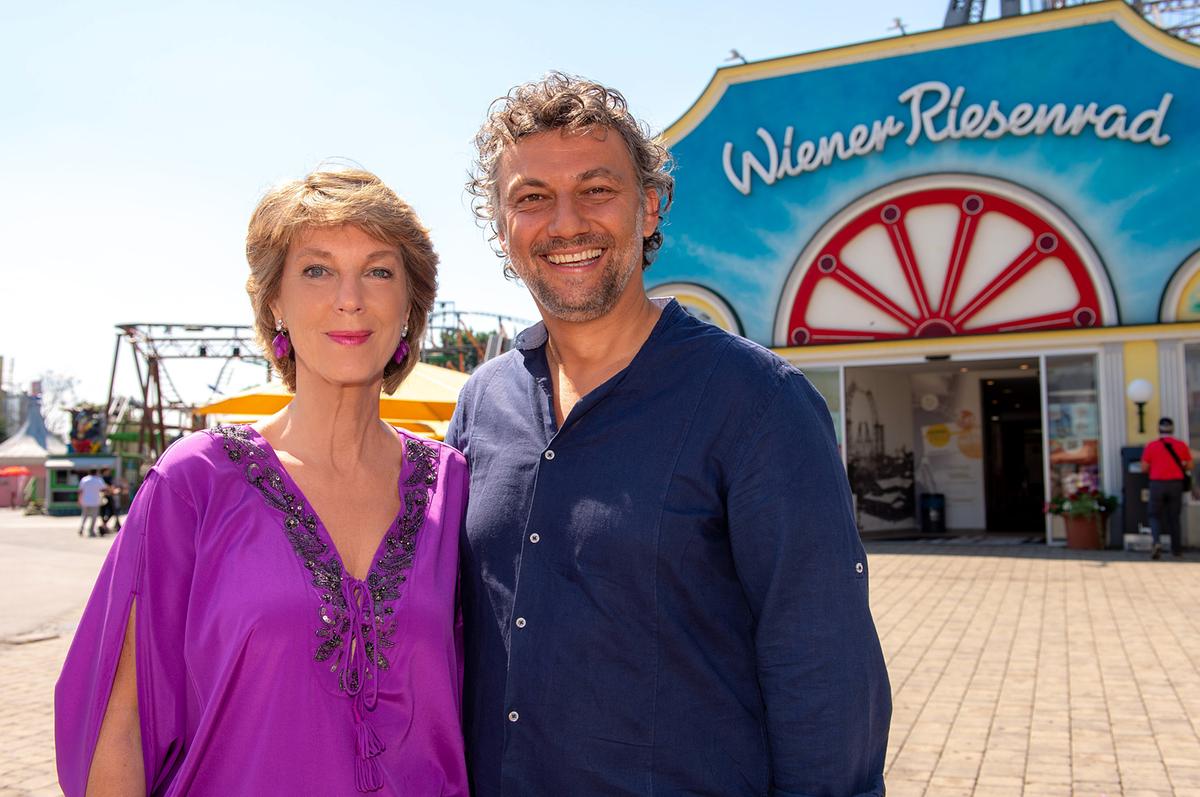 © ORF Barbara Rett und Jonas Kaufmann stehen im Wiener Prater vor dem Riesenrad. Beide lächeln.