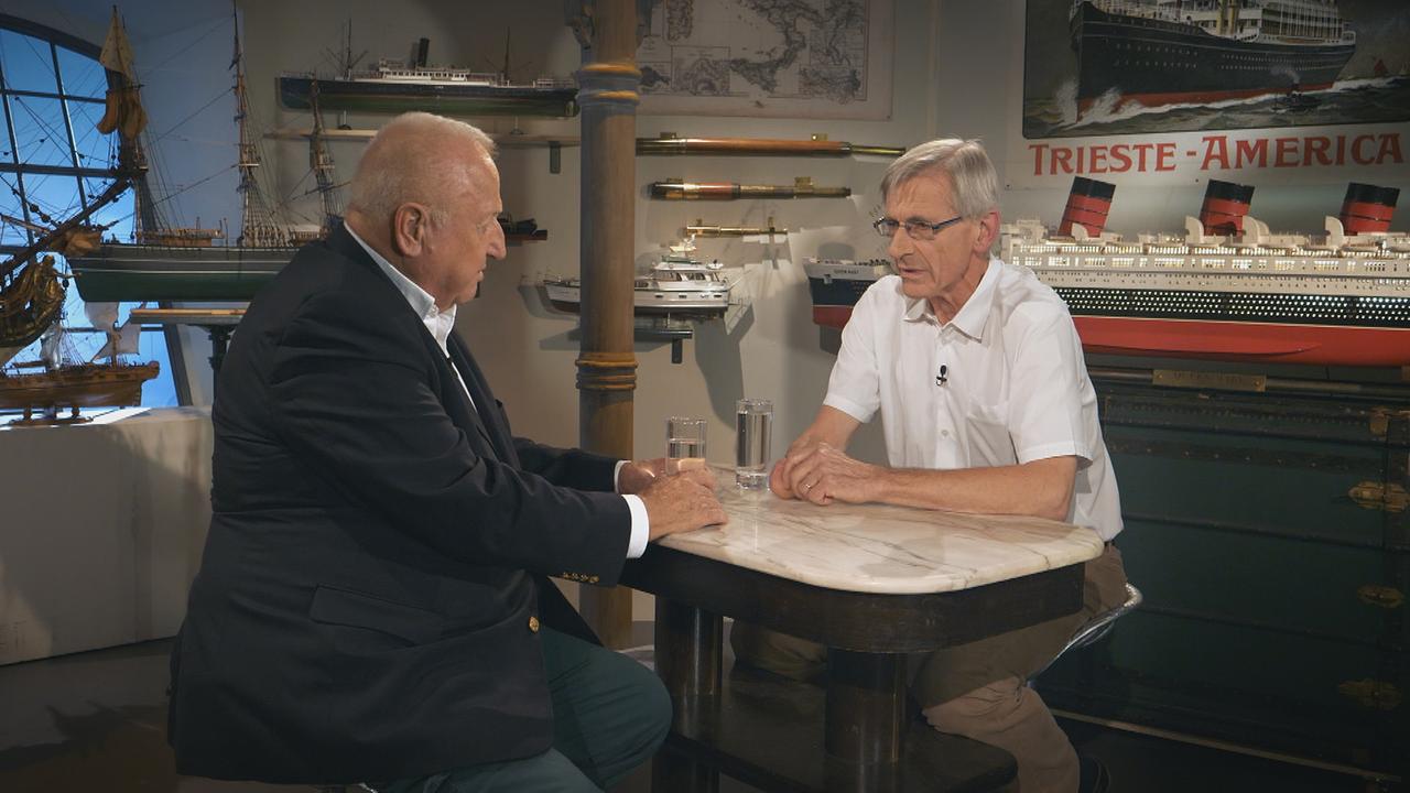 Rudolf Klingohr und Kurt Bednar sprechen über die Austria Americana. Im Hintergrund sind Schiffsmodelle zu sehen.