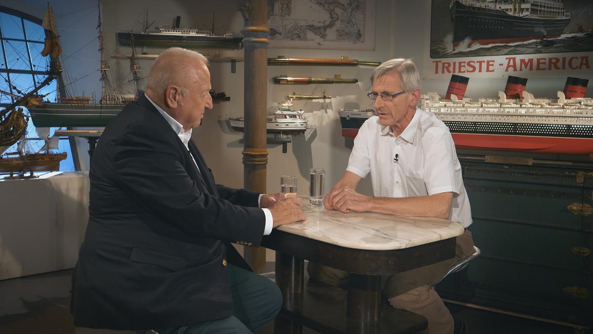 © Tvandmore Rudolf Klingohr und Kurt Bednar sprechen über die Austria Americana. Im Hintergrund sind Schiffsmodelle zu sehen.