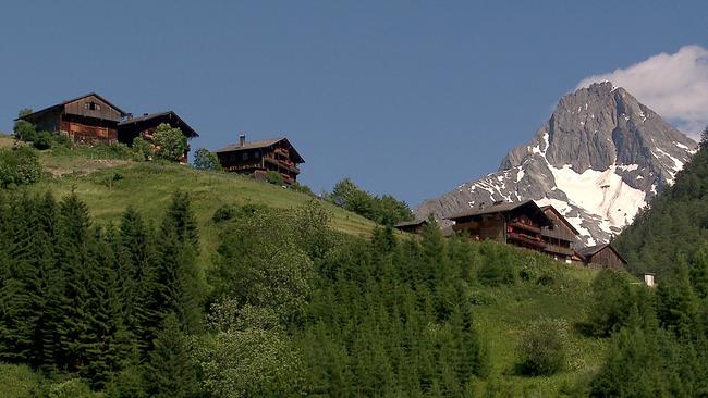Das Villgratental in Osttirol; Knapp 1000 Einwohner hat der größte Ort des Villgratentals. Es zählt zu den ärmsten Regionen Österreichs und ist touristisch kaum erschlossen. Im Bild: Vier Holzhäuser auf einem Hügel, rechts im Hintergrund ein Schneefeld auf einem Felsgipfel.
