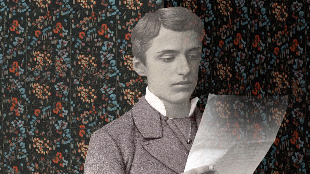 Eine historische Schwarz-Weiß-Aufnahme zeigt einen jungen Mann Theodor Herzl mit einem Manuskript vor einem farbenprächtigen, floralen Hintergrund.
