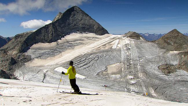 Hintertux Berg mit bisschen Schnee und einem Schifahrer davor