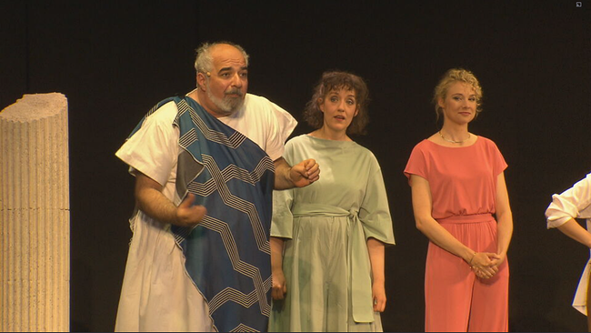 Michael Niavarani & dem Simpl Ensemble stehen in römischen Gewändern auf der Bühne des Theaters im Park 