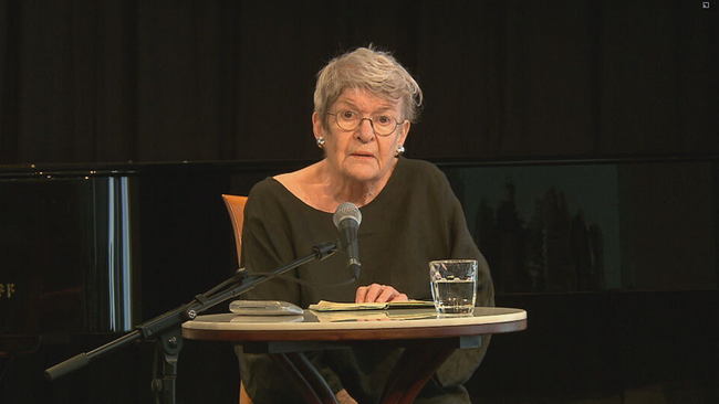 © ORF 2 / Seitenblicke Elisabeth Orth sitzt auf der Bühne an einem Tisch und liest aus einem Buch