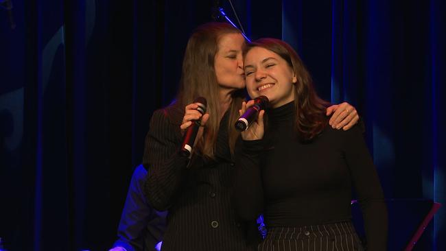 Caroline Vasicek küsst ihre Tochter Marvie auf die Stirn. Beide stehen mit Mikrofon auf der Bühne