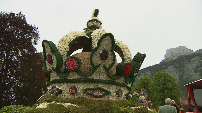 Eine Krone aus Narzissen gemacht vor einer Bergkulisse 