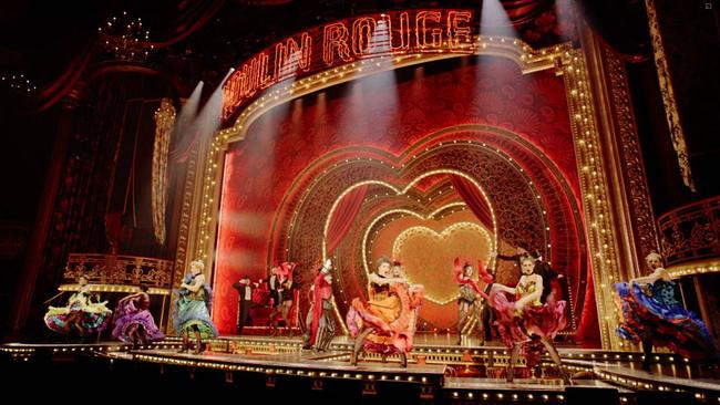 Blick auf die Moulin Rouge Bühne auf der gerade viele TänzerInnen in barocken, bunten Kleidern tanzen