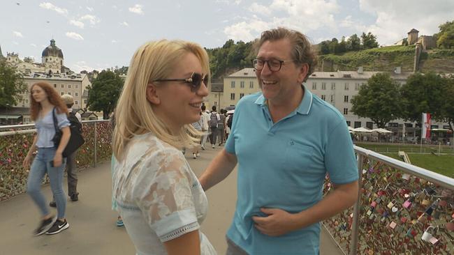© ORF / Seitenblicke Lidia Baich und Andreas Schager stehen auf einer Brücke in Salzburg. Beide lachen