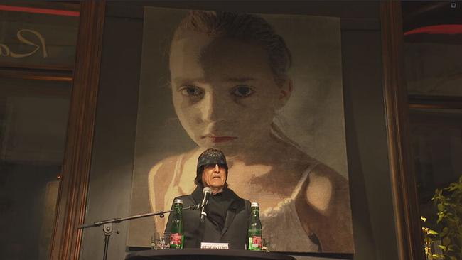 © ORF / Seitenblicke Gottfried Helnwein steht an einem Rednerpult vor dem Wandteppich