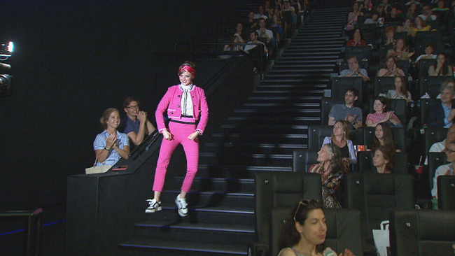 Laura Bilgeri springt ganz in pink gekleidet, freudig die Kinotreppen bei der Premiere "Alle für Uma" herunter