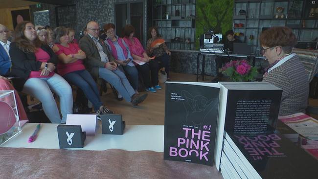 © ORF / Seitenblicke Eine Frau liest aus dem Buch "the pink book", das Publikum sitzt davor
