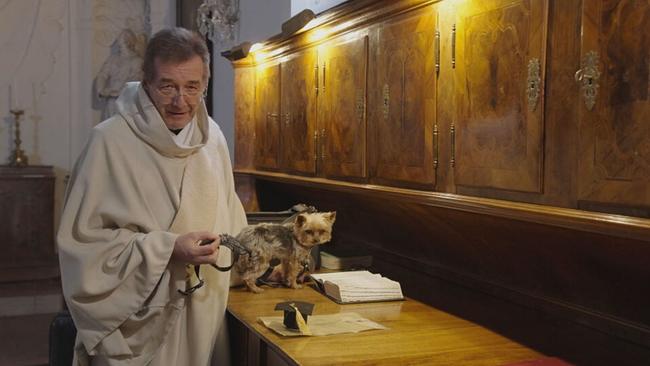 Mönch mit Yorkshire Terrier im Dom