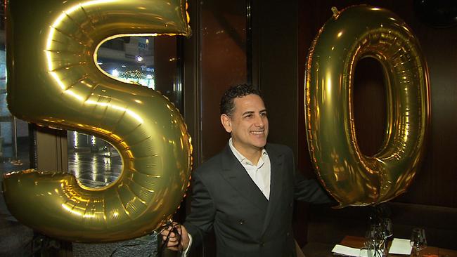 Juan Diego Flórez steht zwischen zwei goldenen Luftballons mit den Zahlen 5 und 0