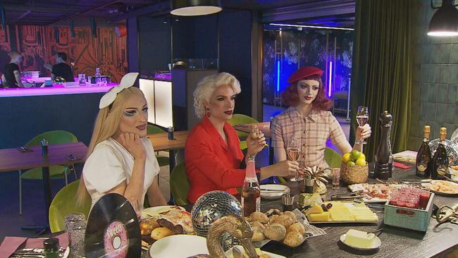 Drag Queens sitzen bei den Proben zur Show an einem Frühstücksbuffettisch