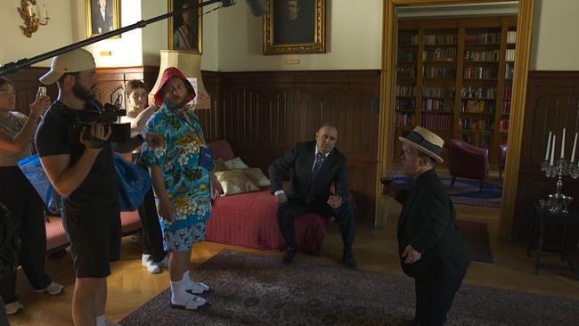 Am Set der Dreharbeiten von "Dave". Dave und zwei Darsteller und Crewmitglieder stehen in einem barocken Wohnzimmer