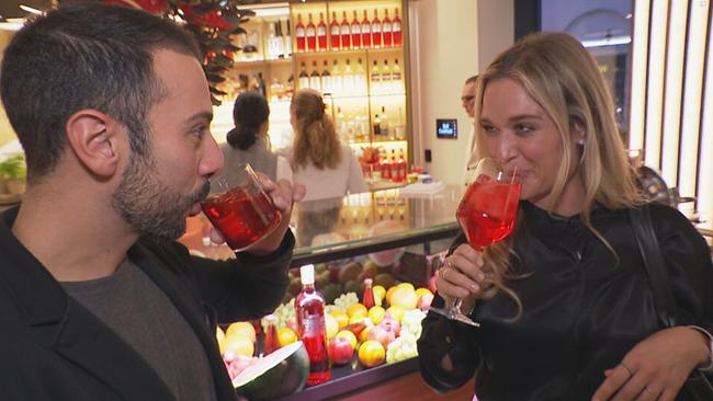 Danilo Campisi und Corinna Kamper trinken aus Gläsern und schauen sich in die Augen