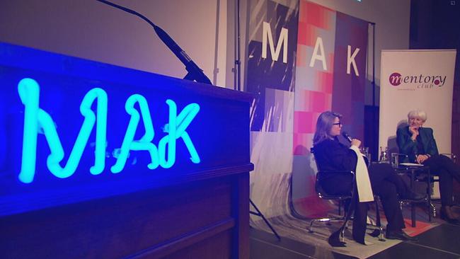 Lilli Hollein und Brigitte Bierlein sitzen auf einer Bühne. Im Vordergrund sieht man in blauer Leuchtschrift: MAK