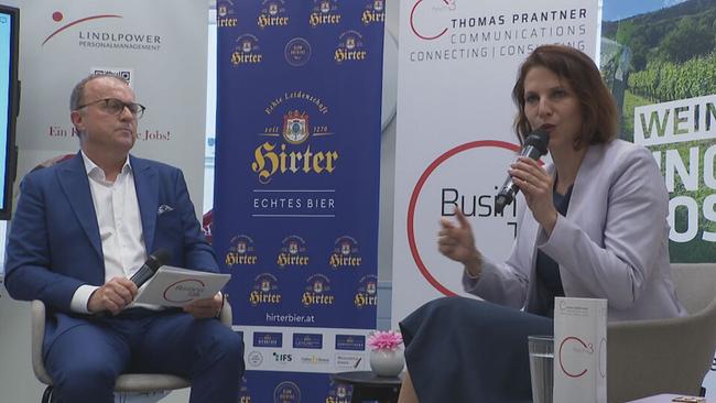 © ORF / Seitenblicke Thomas Prantner sitzt mit Karoline Edtstadler auf einem Podium