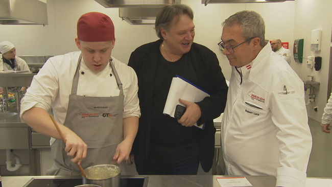 Heinz Hanner schaut Lehrling beim Kochen über die Schulter