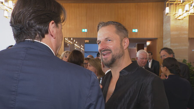 Philipp Hochmair im Gespräch mit Martin Traxl (von hinten) in einem vollen Saal