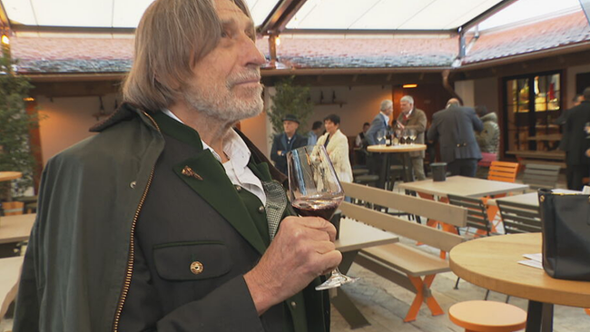 Norbert Blecha schwenkt ein Glas Rotwein