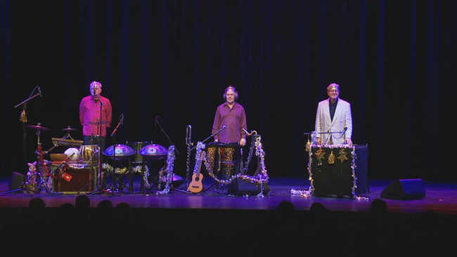 Die drei Herren stehen auf der weihnachtlich-dekorierten Bühne