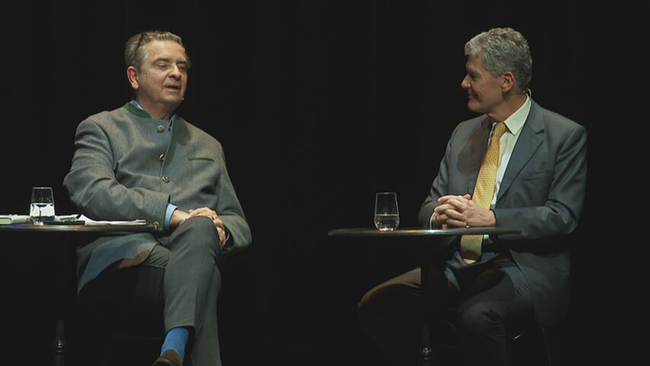 Christoph Wagner-Trenkwitz und Karl Hohenlohe sitzen gemeinsam auf der Bühne an Tischen