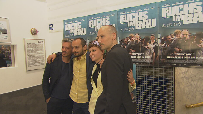 Regisseur und SchauspielerInnen posieren im Haydn Kino vor dem Plakat "Fuchs im Bau"